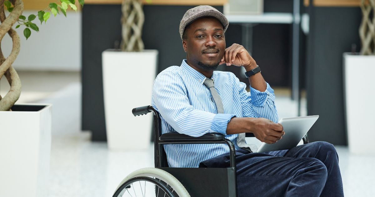 black man in a wheelchair at the office working